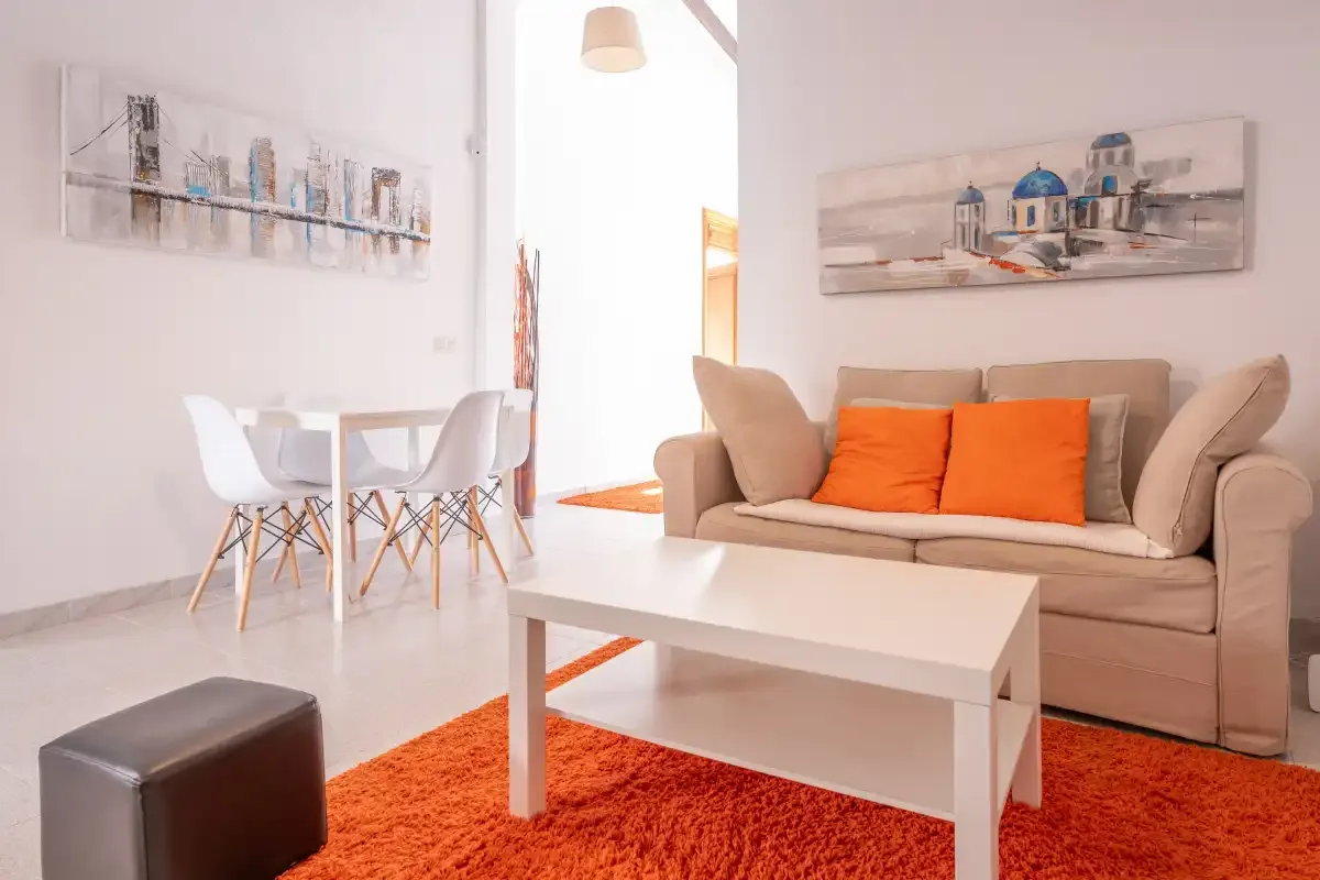 A living room with seating, a white coffee table, and a dining area.