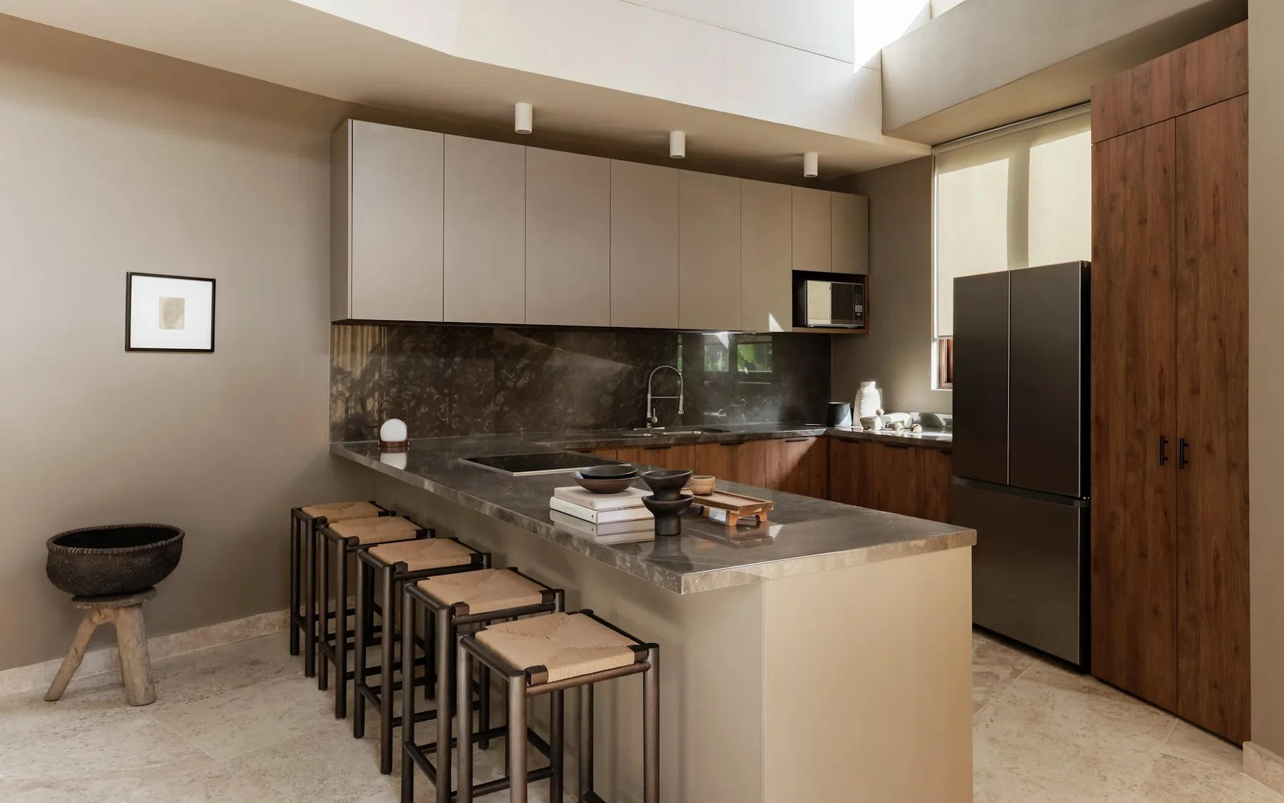Una cocina moderna con una isla grande y taburetes.
