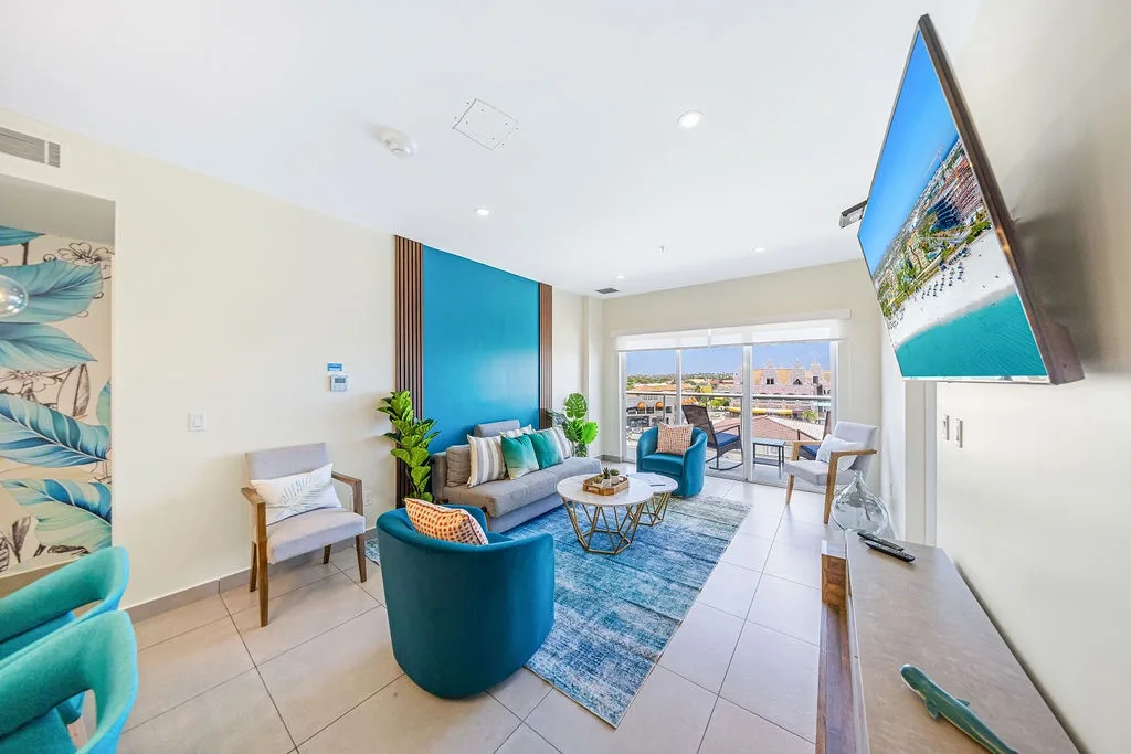 Relax in your bright, modern living room featuring coastal-inspired décor, plush seating, and a large TV—your perfect retreat after a day of island adventures.