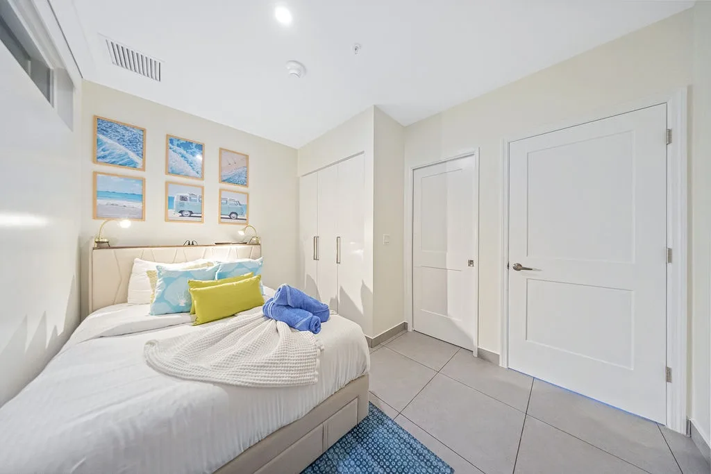 Relax in your bright, beachy bedroom with crisp linens, coastal artwork, and ample storage. The vaulted ceiling and fresh towels await your arrival.