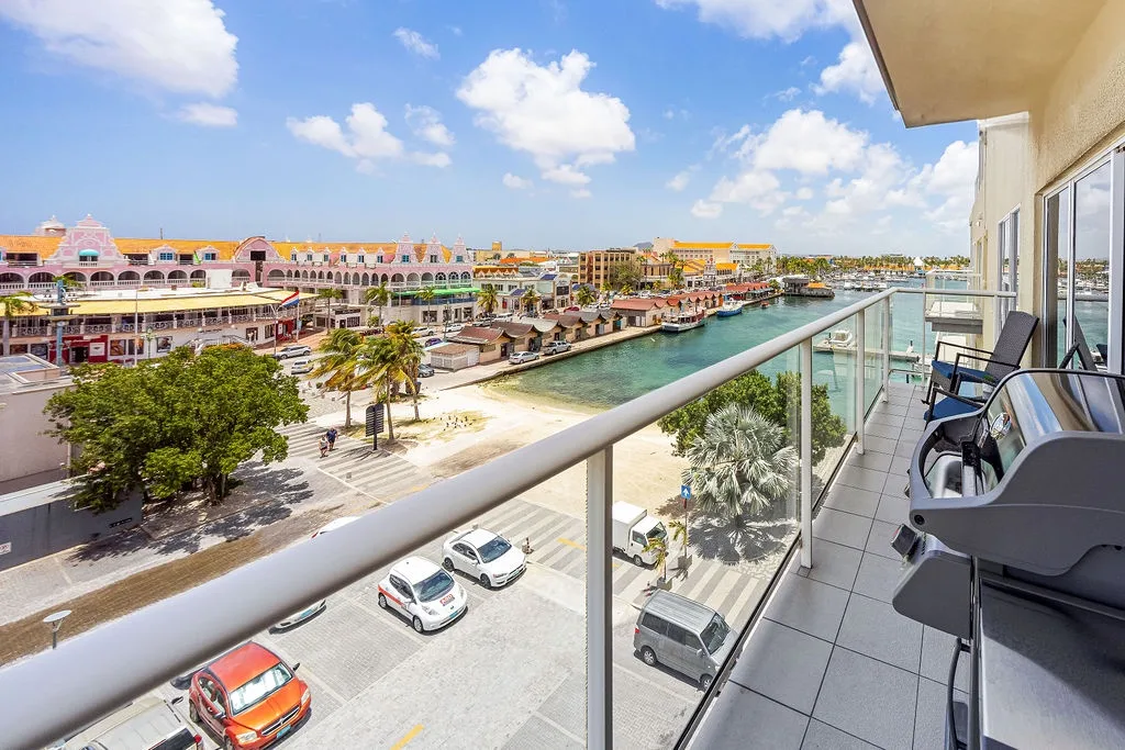 Step onto your private balcony and soak in sweeping views of colorful waterfront buildings, palm-lined streets, and the sparkling marina below—your front-row seat to this vibrant coastal escape.