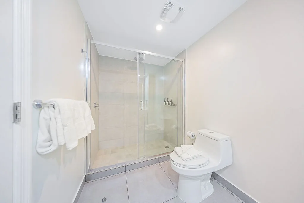Step into your spa-like bathroom with a spacious glass-enclosed shower, plush towels, and sleek modern finishes that make freshening up feel effortless.