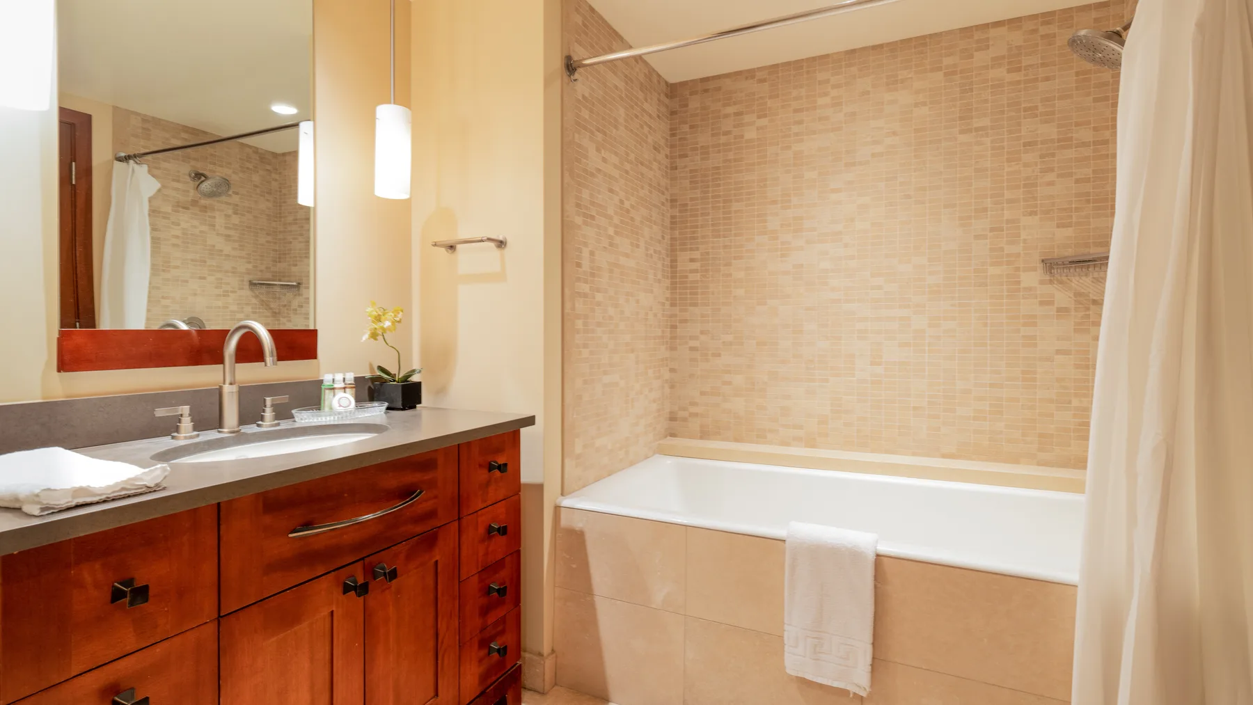 Un lavabo de baño está junto a una bañera con cortina de ducha.