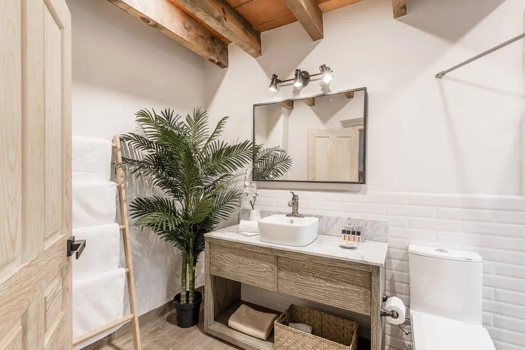 Bathroom with wooden beams, white subway tile wall, and wooden vanity with vessel sink
