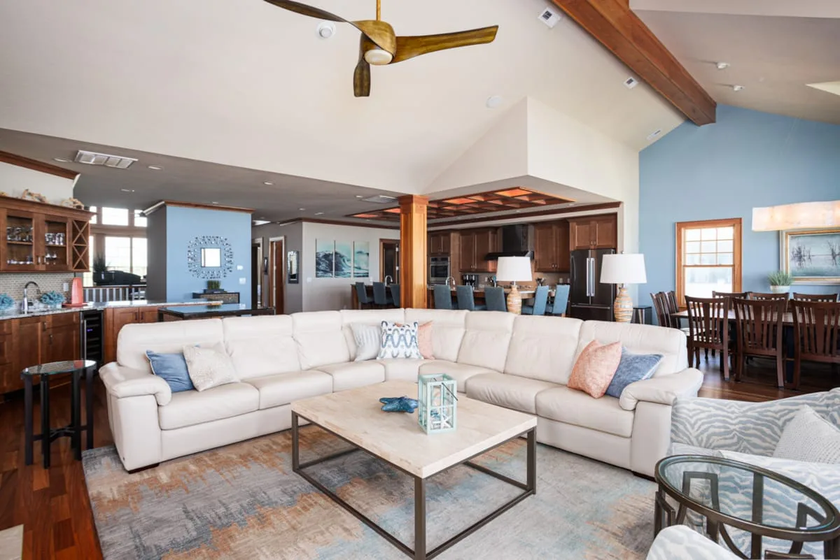 Open-plan living area with sectional seating beside the kitchen and dining table.