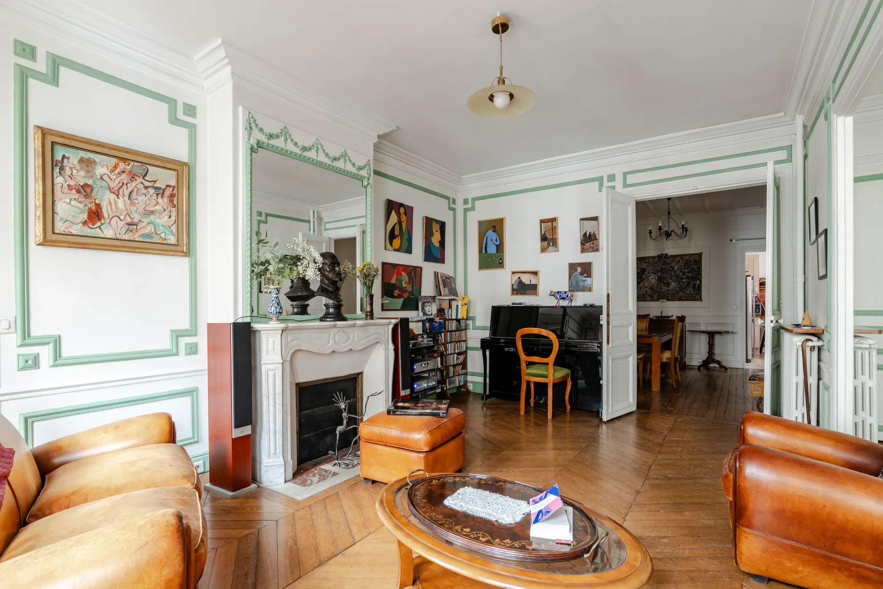 A decorated living room with framed artwork, seating, and a fireplace.