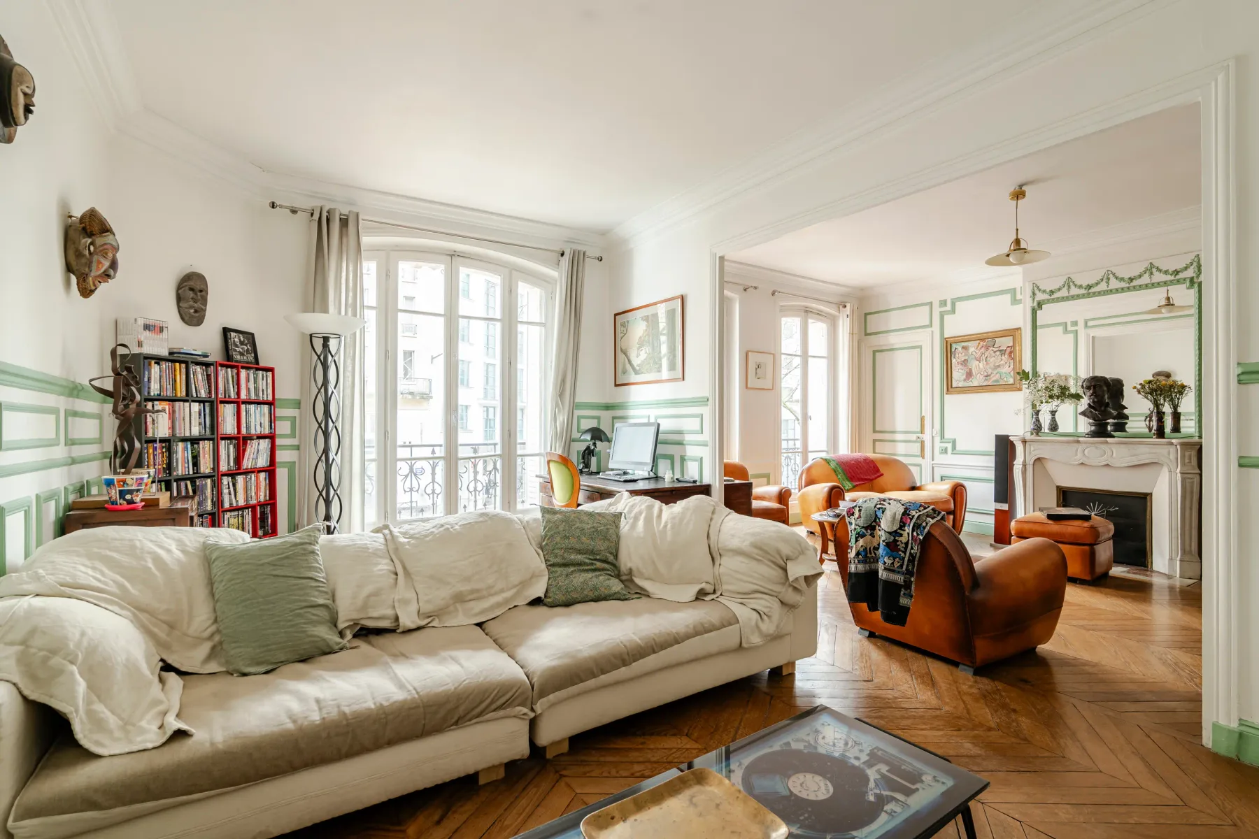 A bright living room with a large sofa and armchairs.