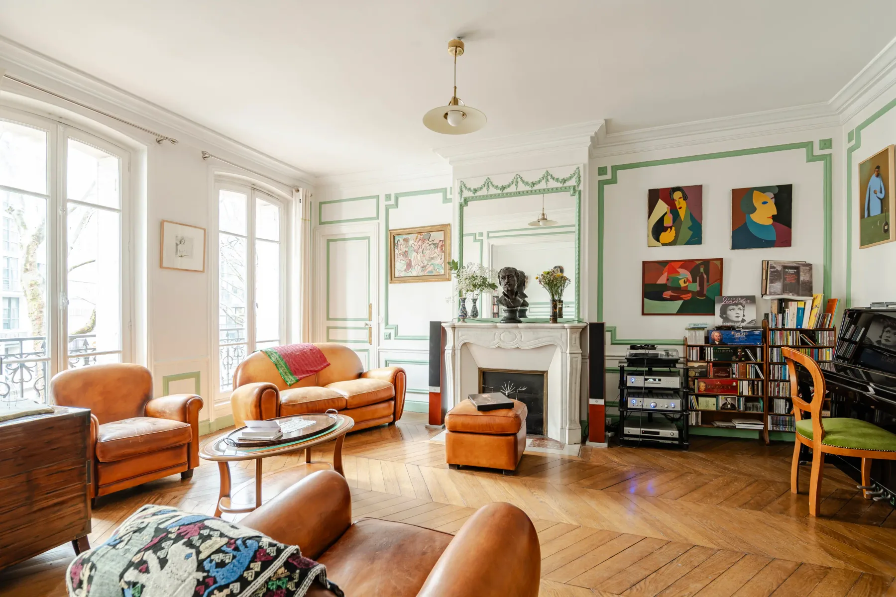 Bright living room with colorful artwork, seating, and a fireplace.
