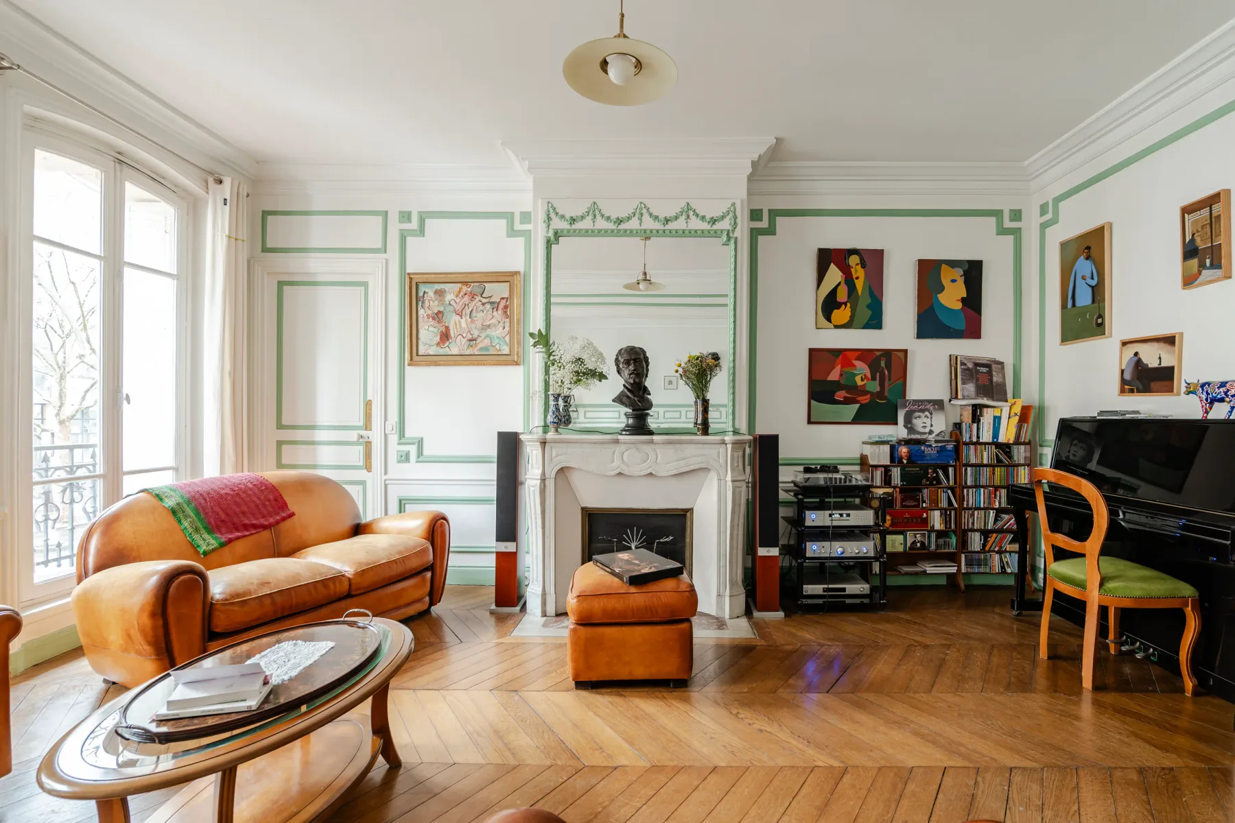 A living room with a fireplace, colorful artwork, and seating.