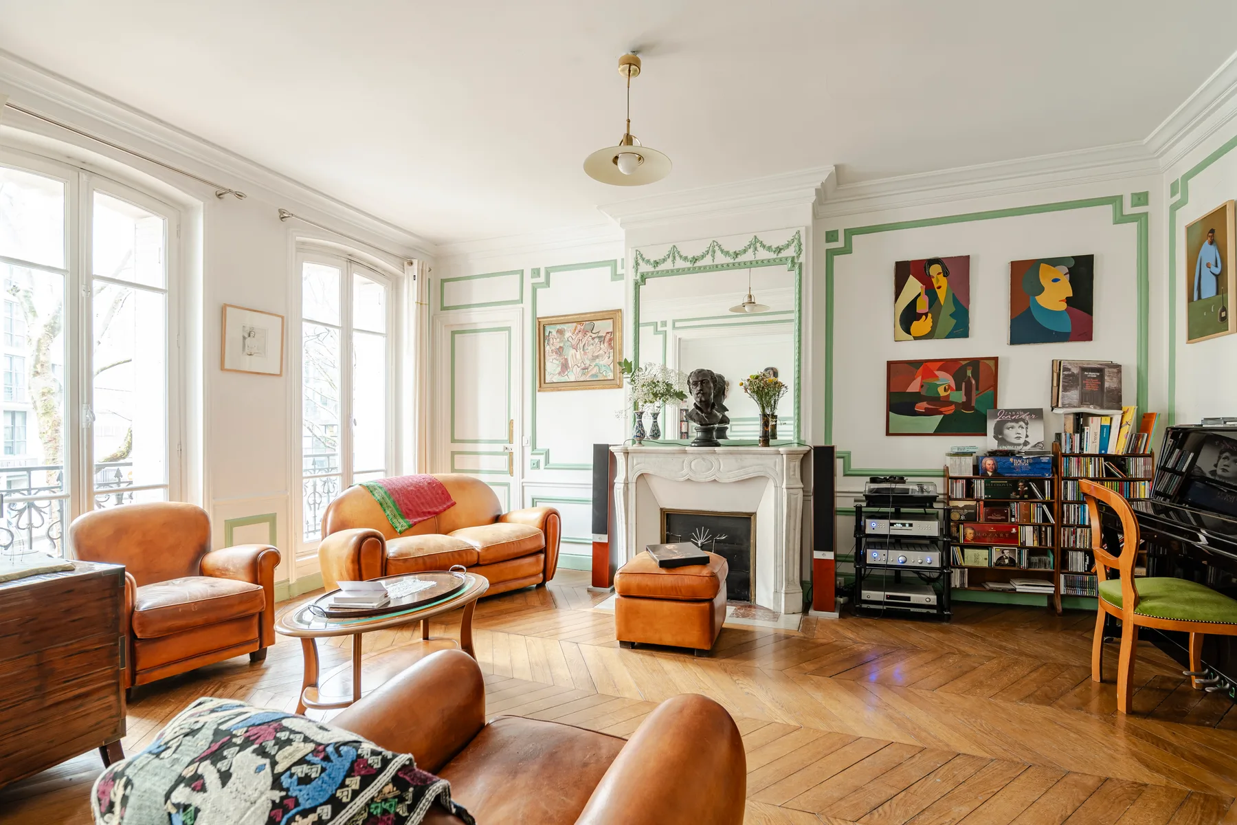 A bright living room with seating, a fireplace, and bookshelves along the wall.