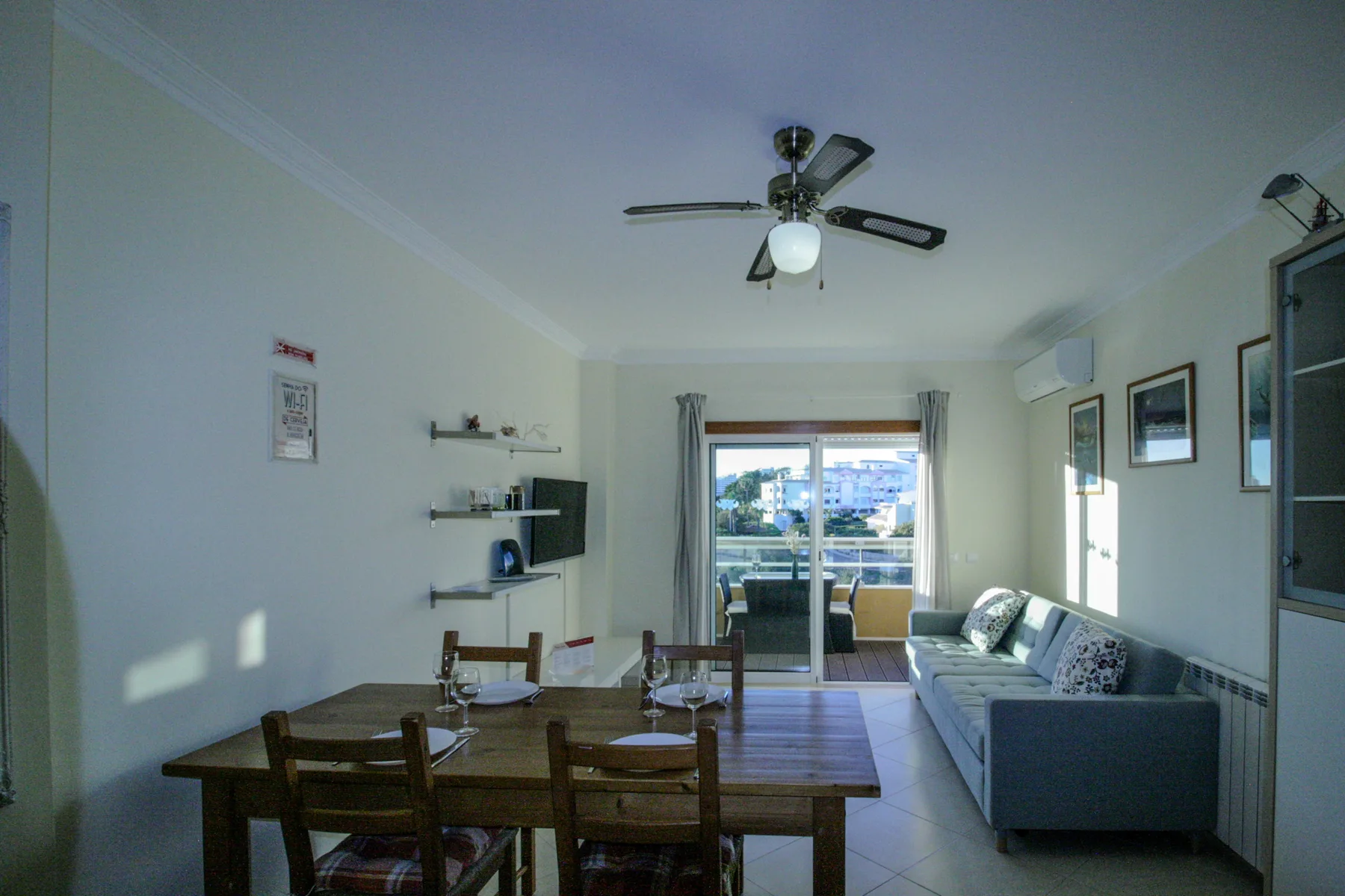 A living and dining room with a table, seating, and a sofa beside the window.