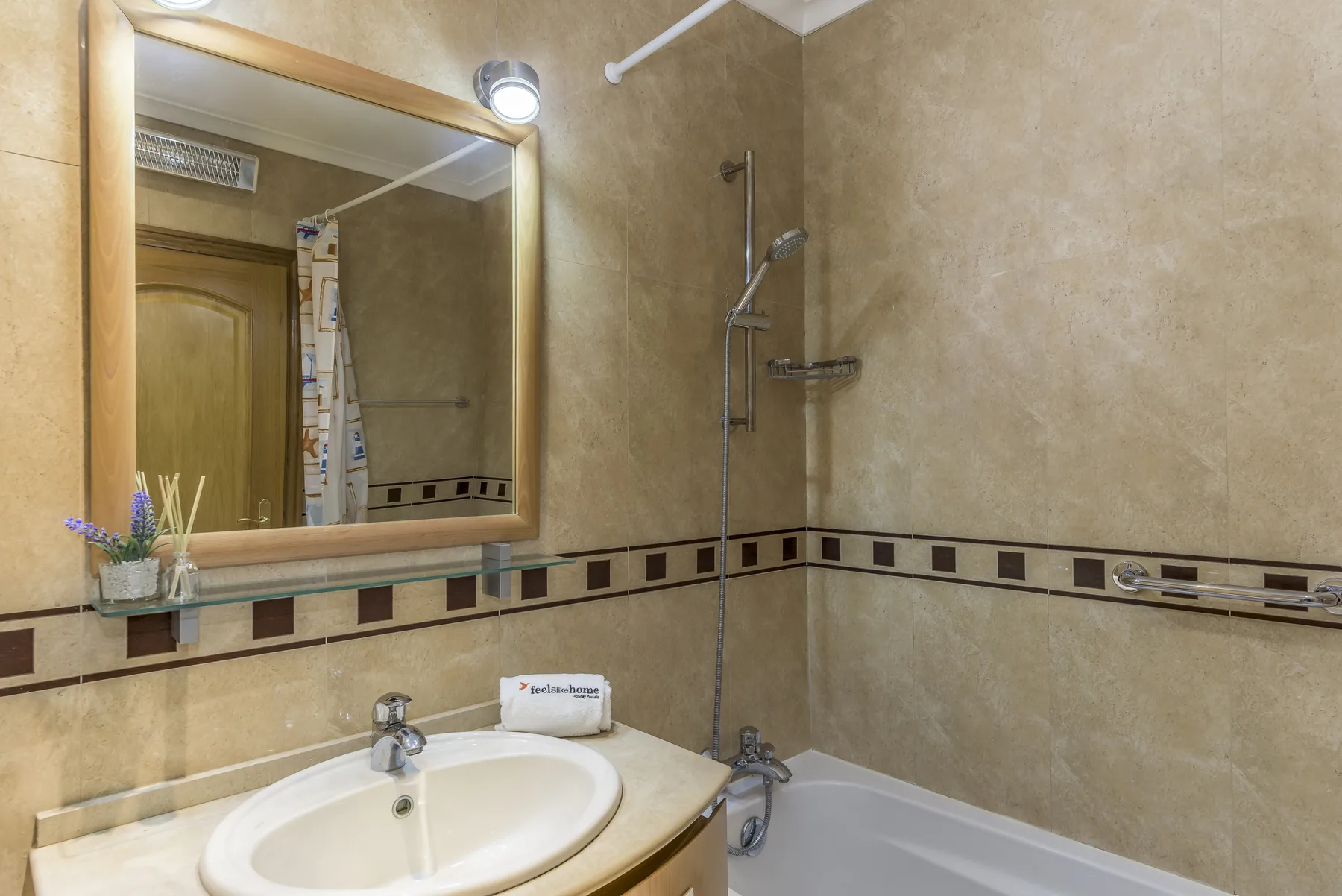 A bathroom with a sink, mirror, and bathtub.