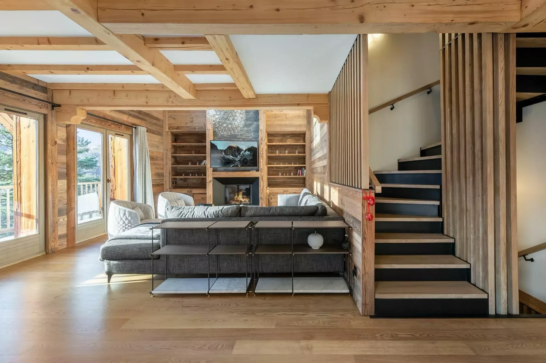 Una sala de estar de madera con asientos, estanterías y una escalera.