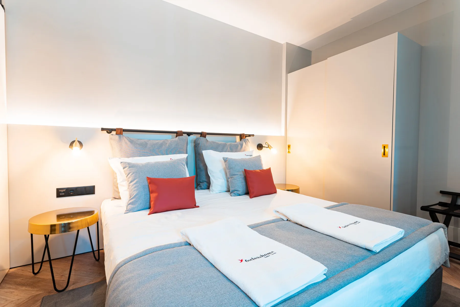 A bedroom with a neatly made bed and blue bedding.
