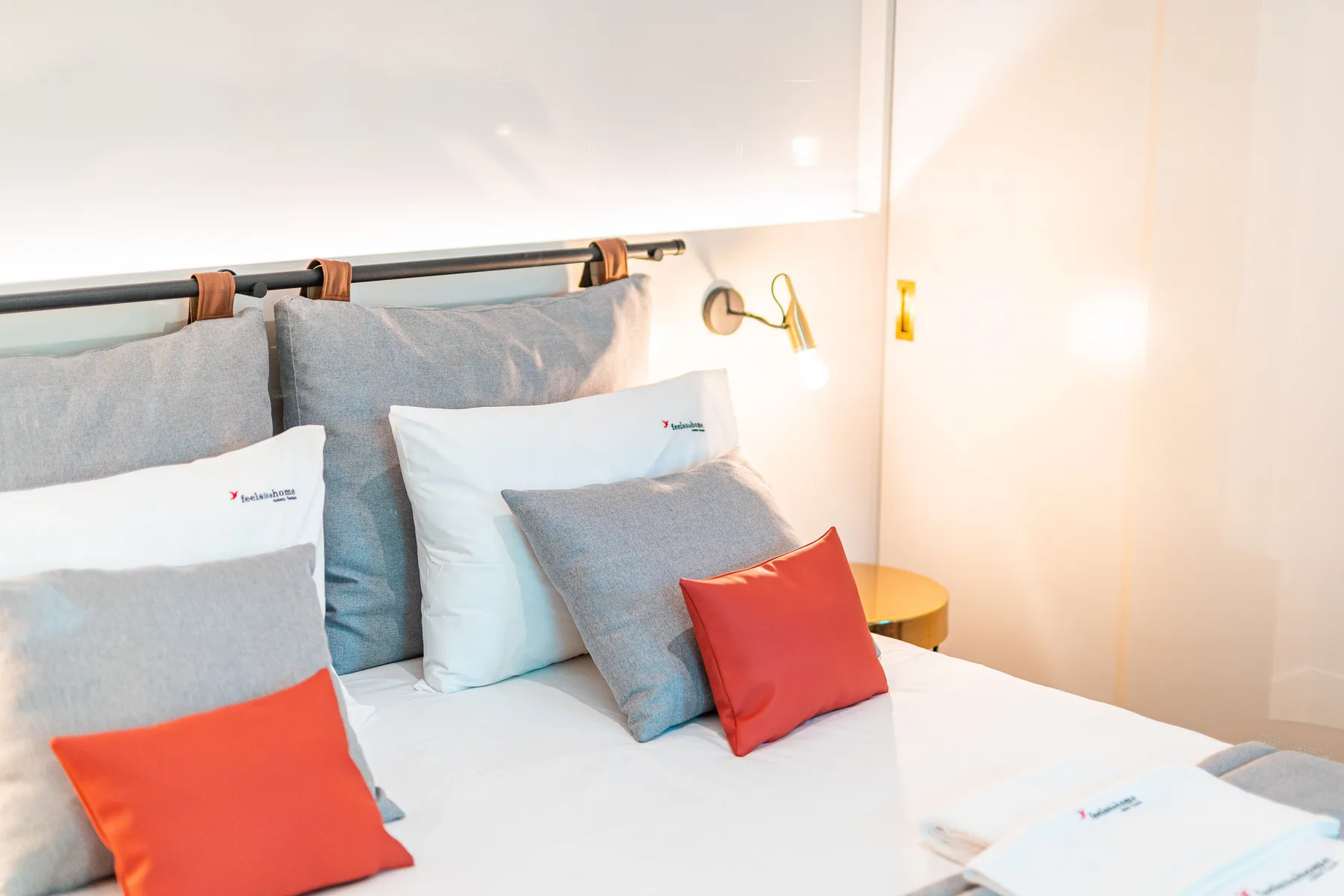 A bedroom with a neatly made bed and gray pillows.