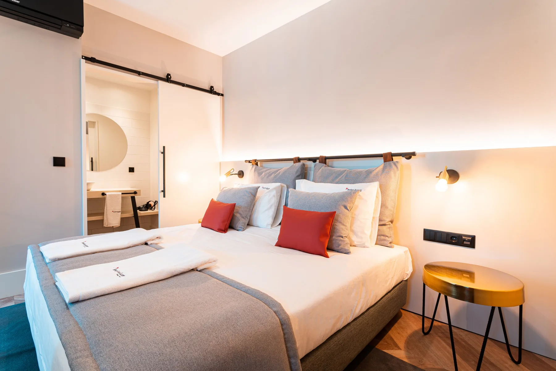 Bedroom with a neatly made bed and a small bedside table.