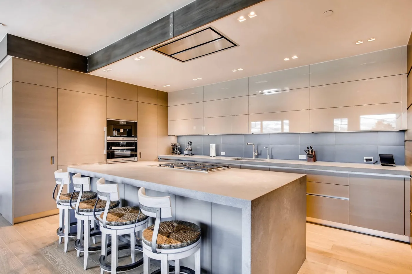 Una cocina moderna cuenta con una gran isla con asientos y electrodomésticos integrados.