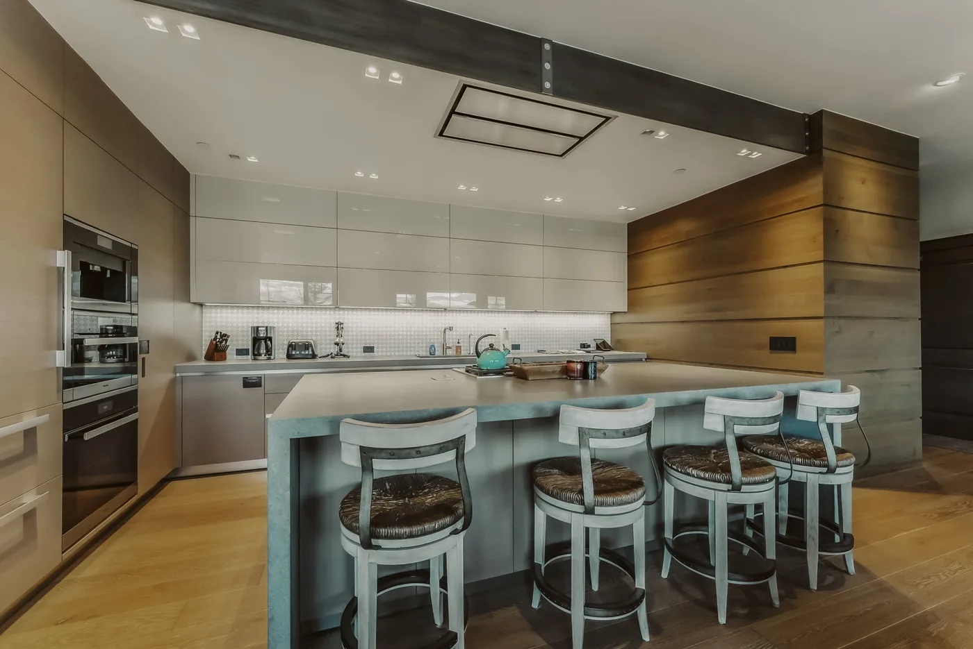 Una cocina moderna con una gran isla y taburetes.