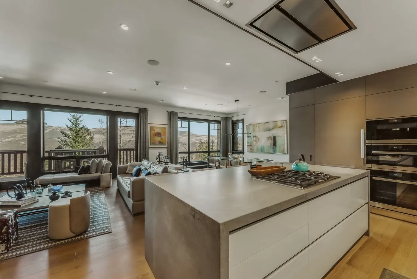 Una cocina abierta al salón, con una isla grande y amplias ventanas.