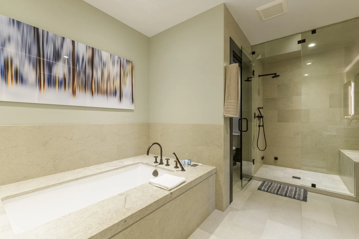 Un baño con bañera y ducha con mampara de vidrio.