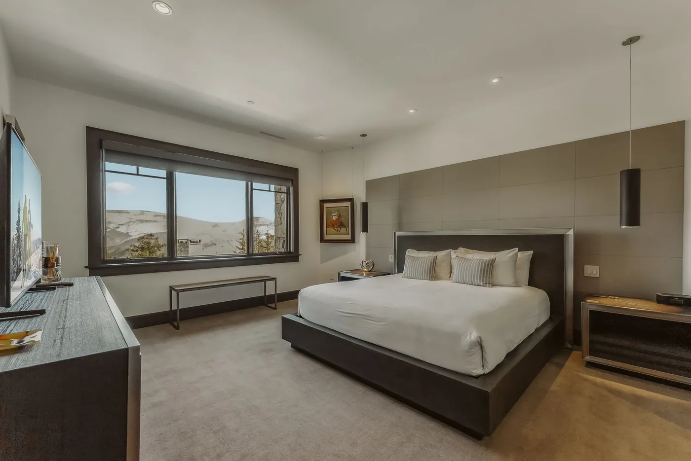 Un dormitorio moderno con una cama grande y una amplia ventana con vistas al paisaje.