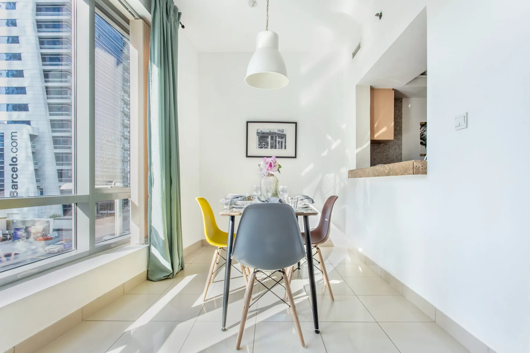 Un comedor luminoso con una mesa junto a grandes ventanales.
