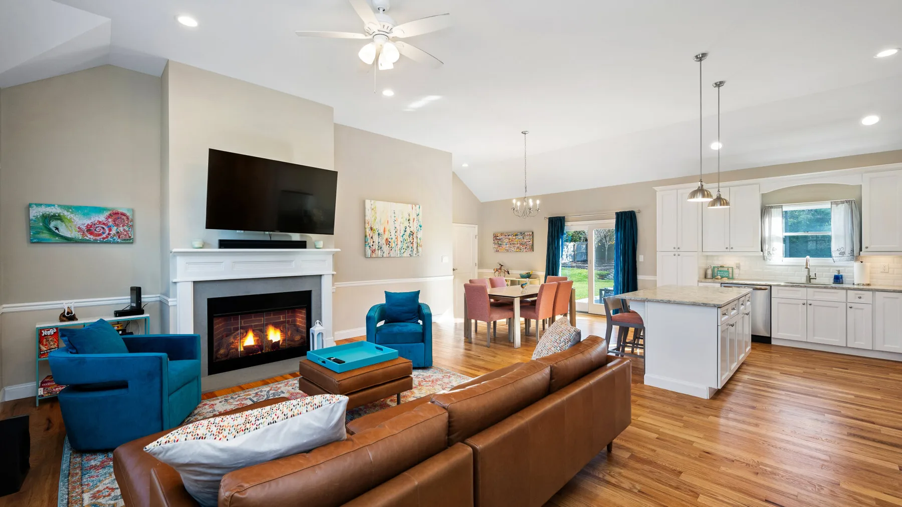 Sala de estar y cocina de concepto abierto, con asientos, chimenea y comedor.