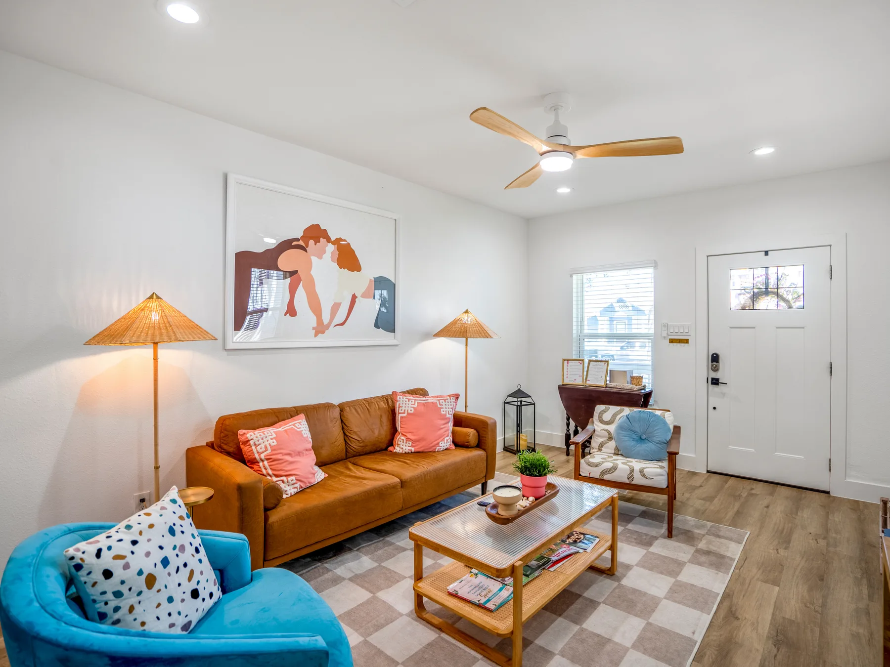A bright living room with a brown sofa, blue armchair, and coffee table.