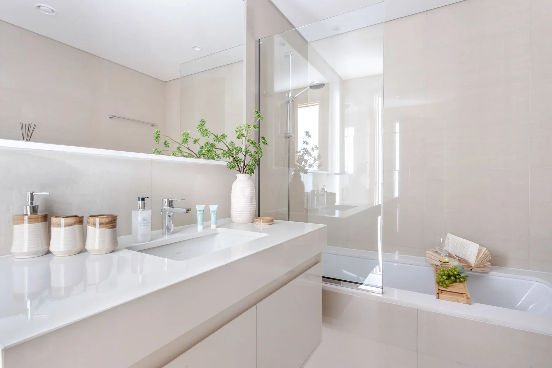 Un baño luminoso con un lavabo amplio y una ducha de vidrio.