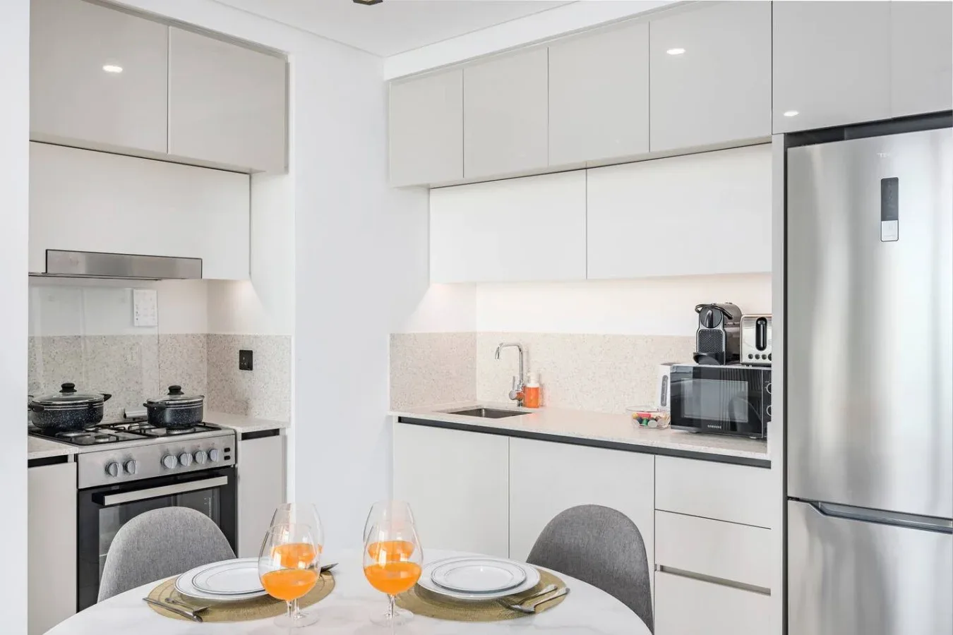Una cocina luminosa con estufa, encimera y mesa de comedor.