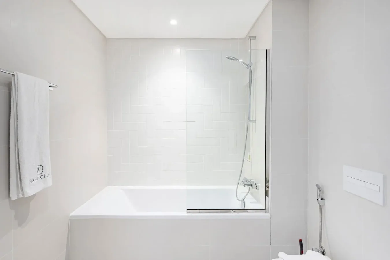 Un baño luminoso con bañera y ducha.