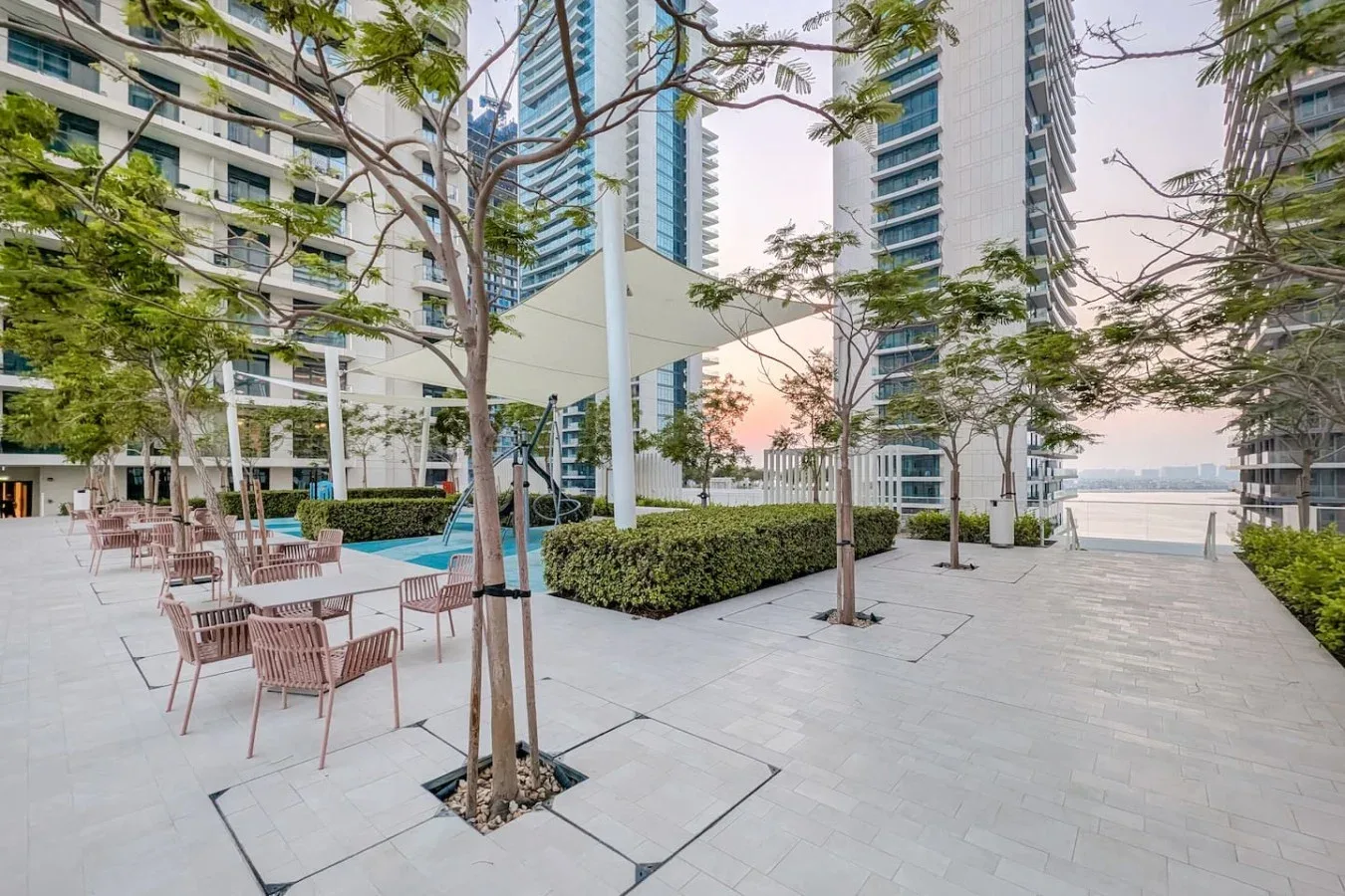 Una terraza al aire libre con asientos, jardineras y edificios altos.