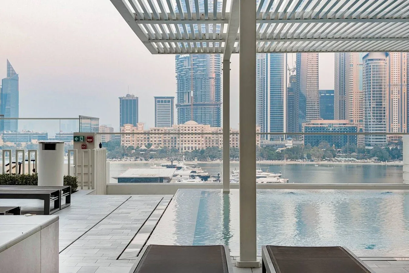 Una terraza con piscina junto al agua ofrece vistas de edificios altos.