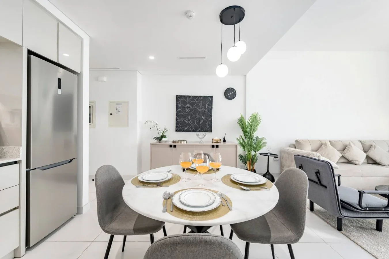 Un comedor y sala de estar diáfanos y luminosos, con una mesa redonda y asientos.