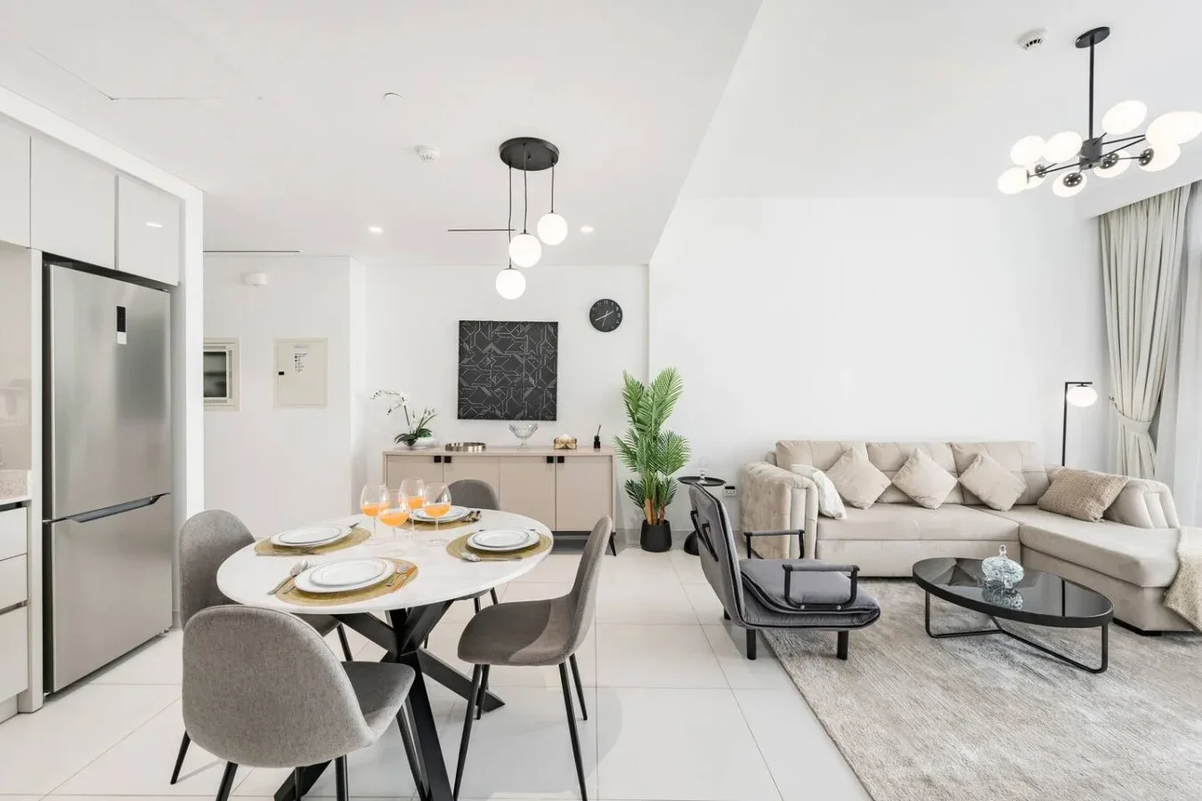 Una luminosa sala-comedor diáfana con mesa, asientos y un sofá.
