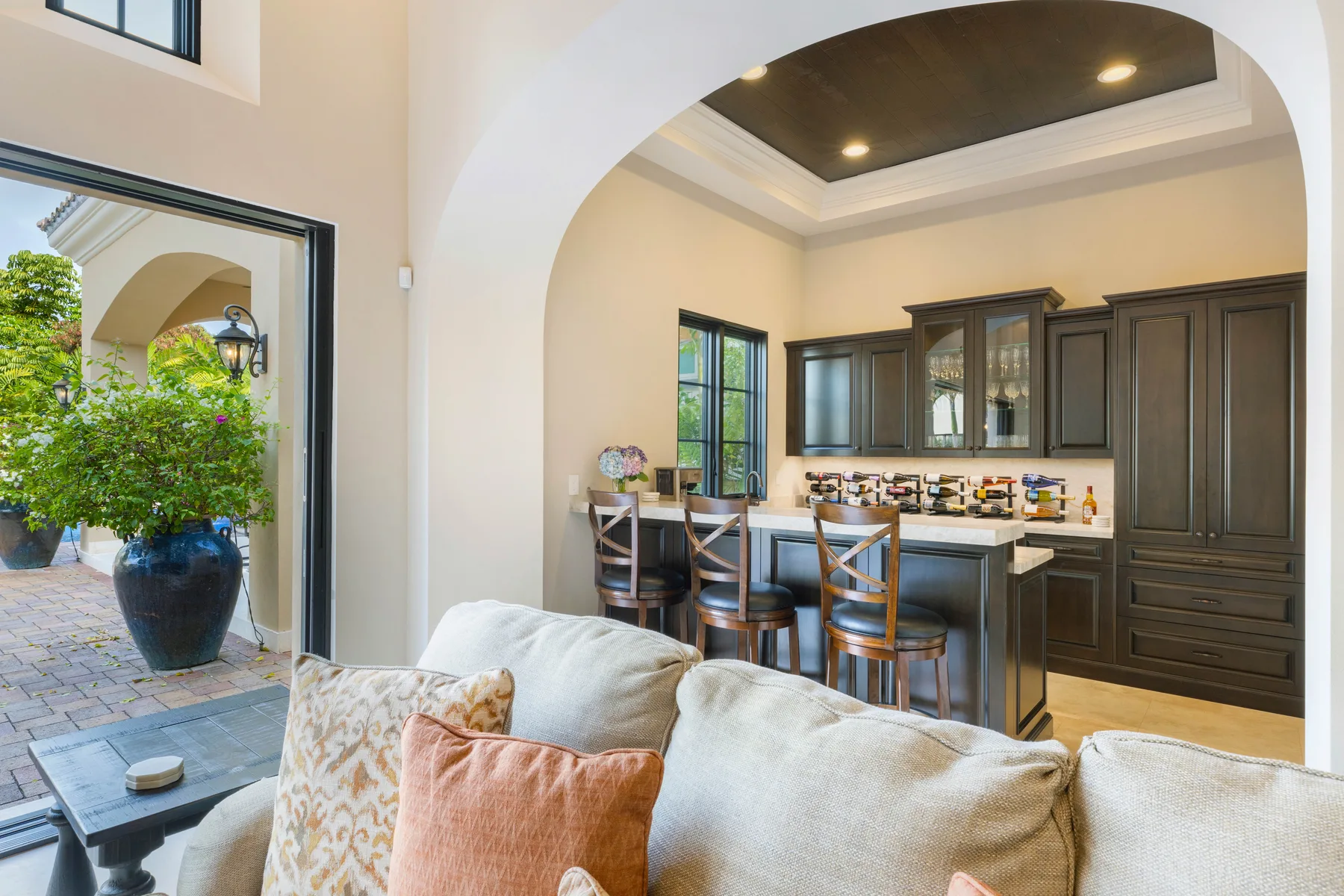A living area opens into a kitchen with dark cabinetry and a counter.