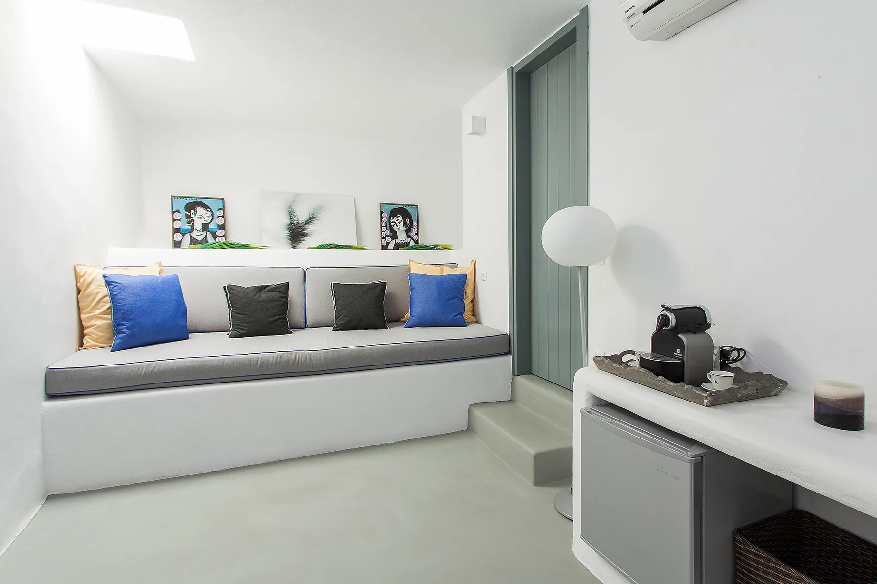 A bright sitting area with a cushioned bench and a small refreshment station.
