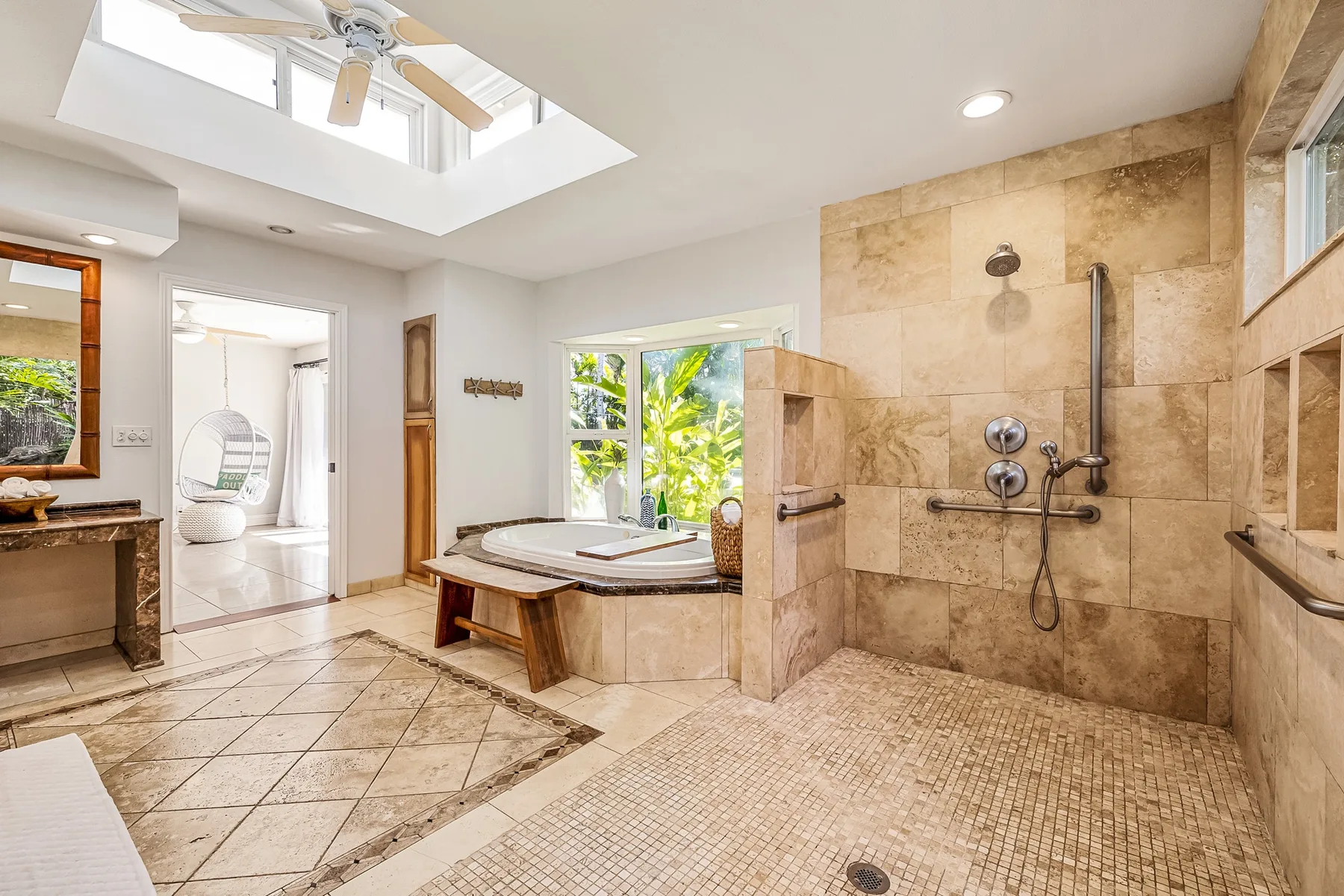 Un baño amplio con zona de ducha revestida de azulejos y bañera empotrada.