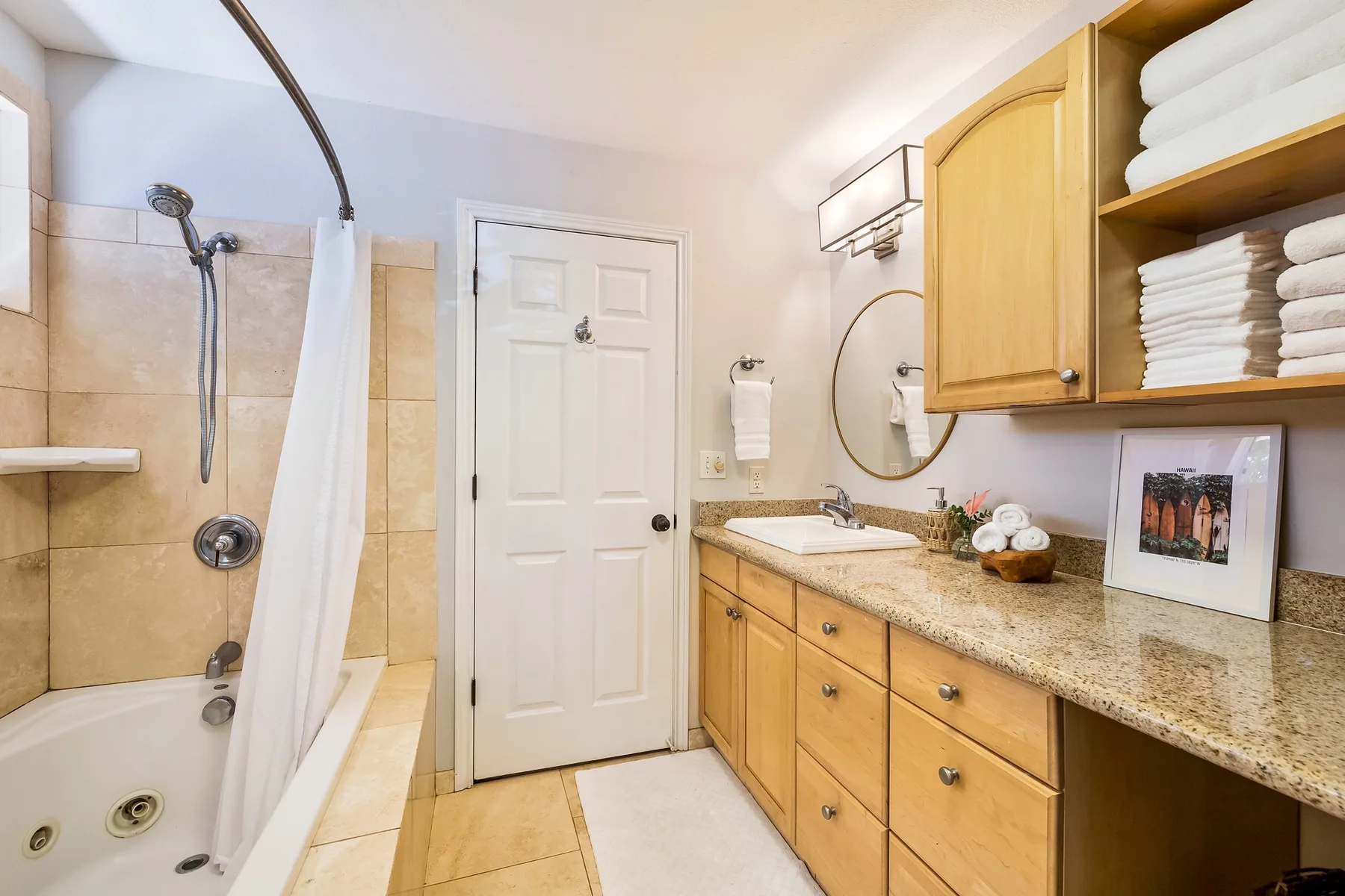 Un baño con bañera, lavabo y muebles de madera.