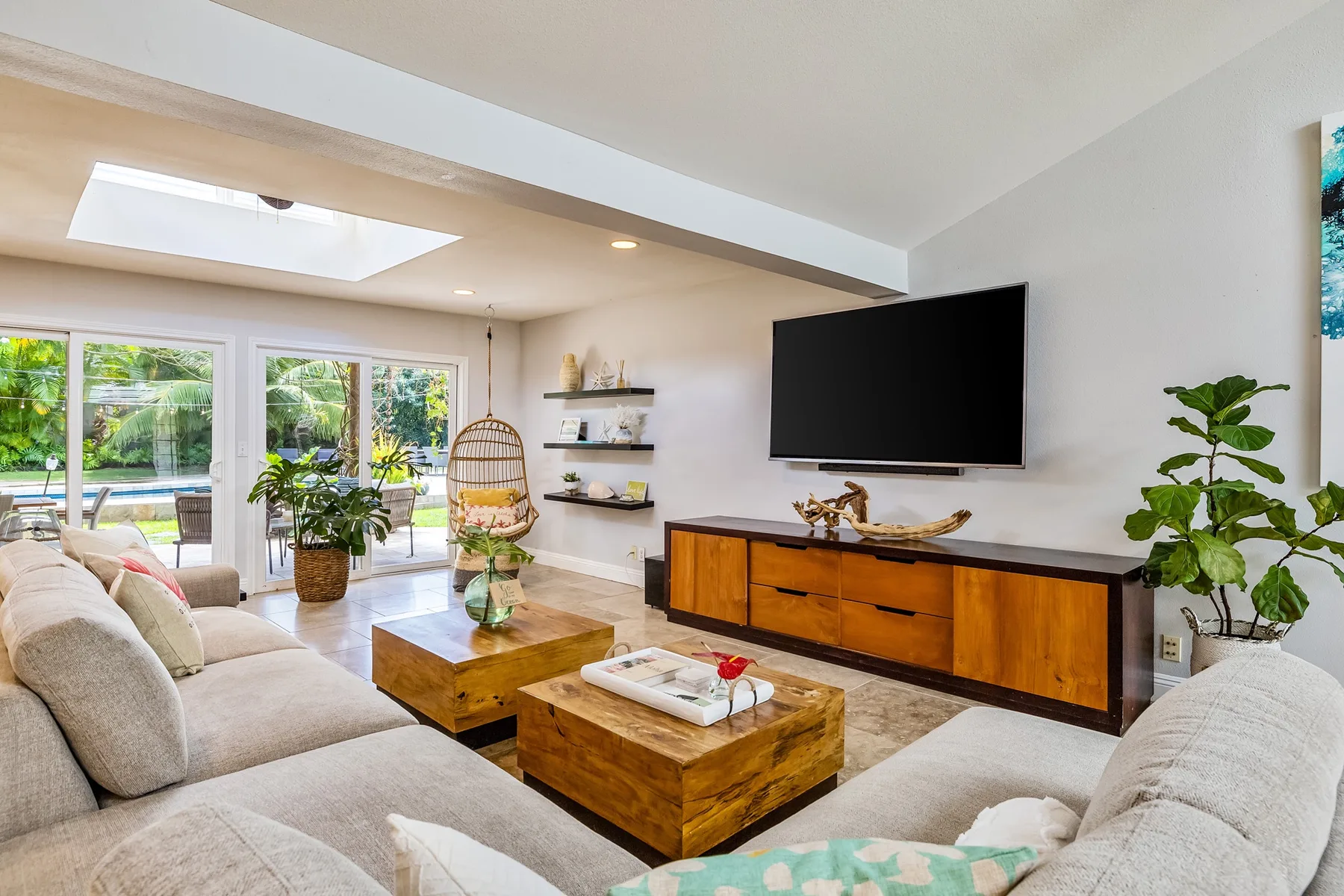 Una sala luminosa con un televisor sobre un mueble de madera.
