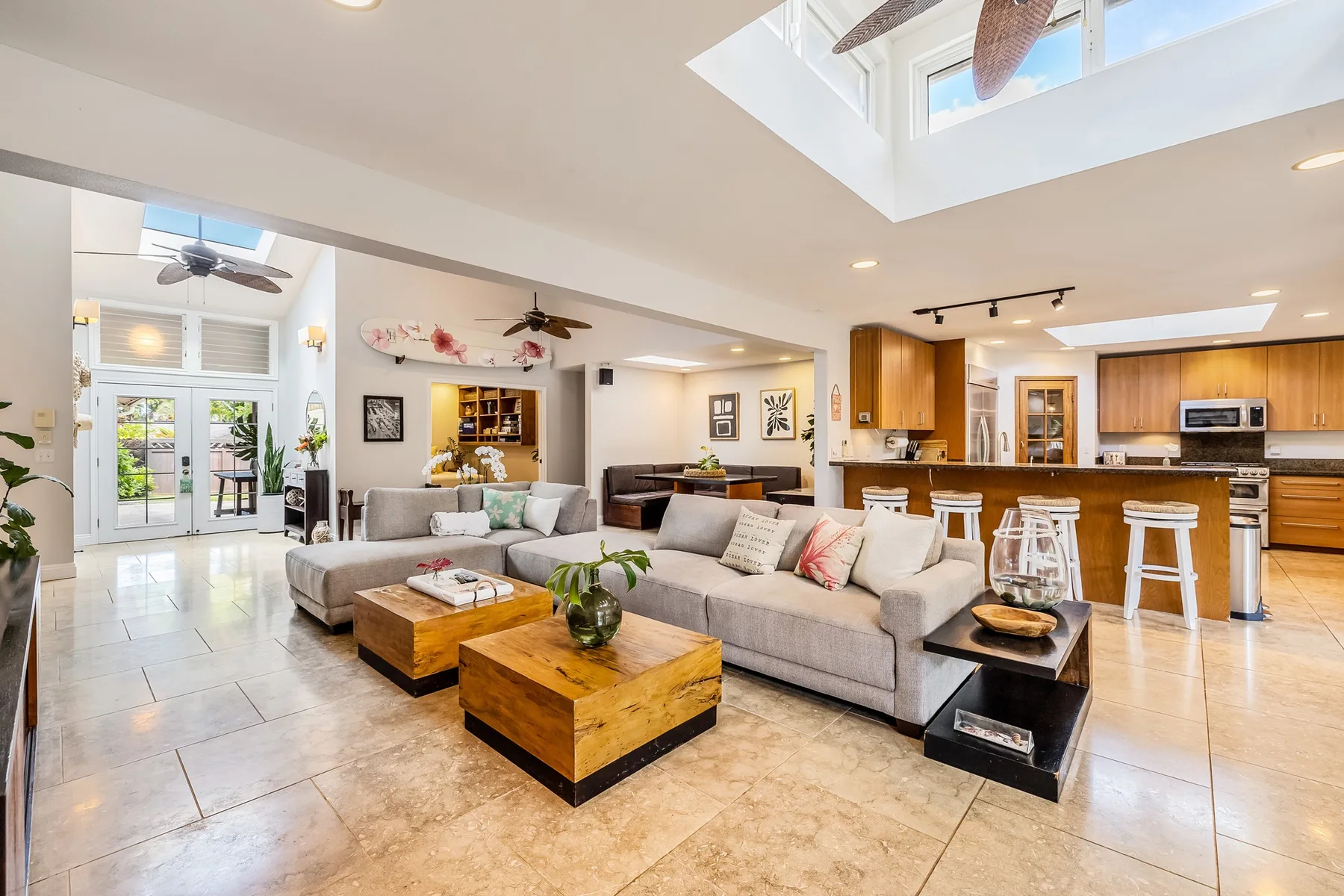 Sala de estar y cocina de concepto abierto, con una amplia zona de asientos y una barra.