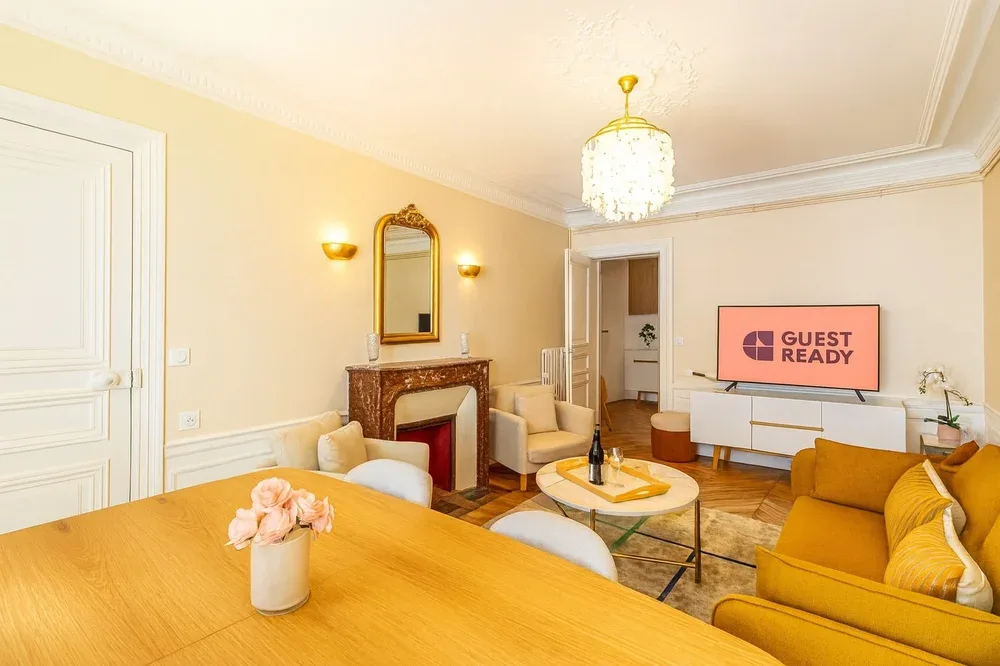 A bright living room with a dining table, fireplace, and seating.