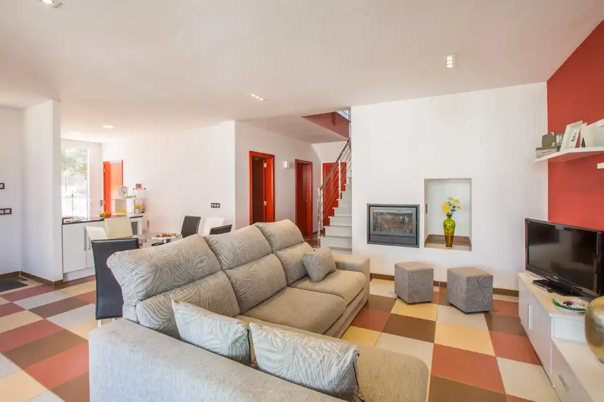 A living room with seating, a television, and a fireplace.