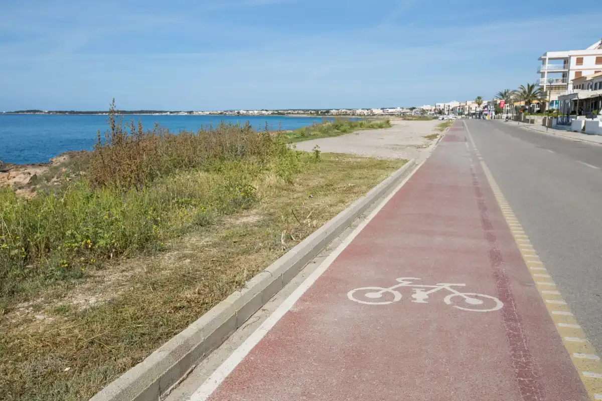 A coastal bike path runs beside the sea and a road.