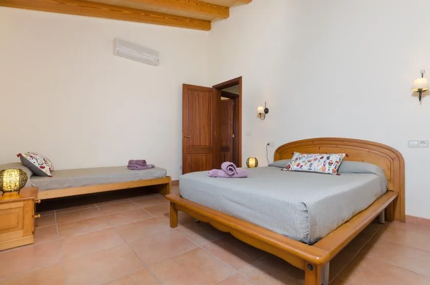 A bedroom with a wooden bed and a narrow daybed against the wall.