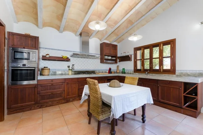A kitchen and dining area with wooden cabinets, a table, and chairs.