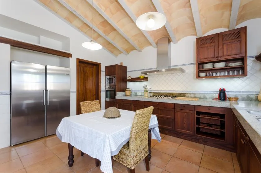 A kitchen and dining area with dark wood cabinets and a table.