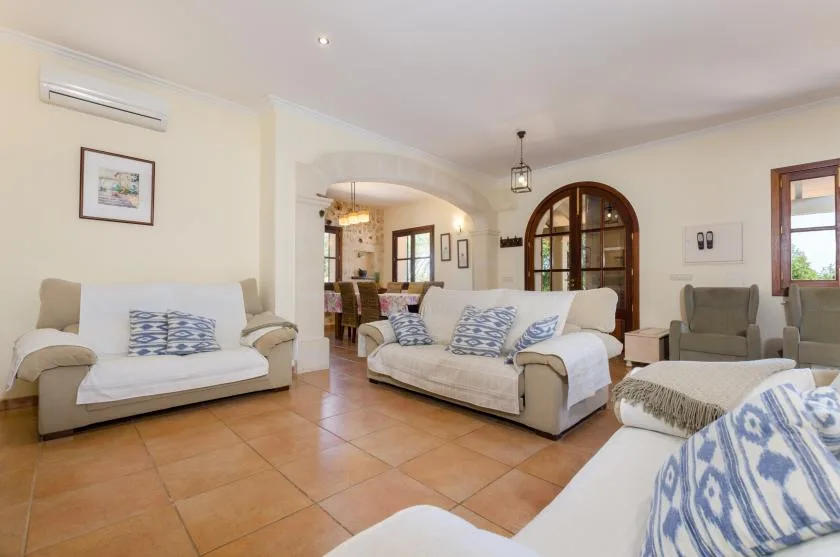 Living room with seating arranged around a tiled floor.