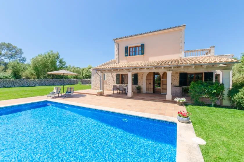 A house with a swimming pool and a shaded patio.