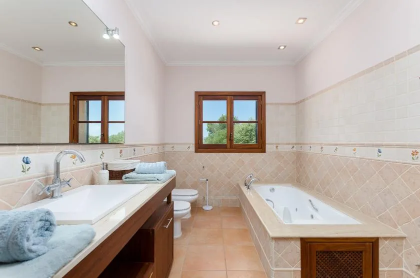A bathroom with a bathtub, a sink, and tiled walls.